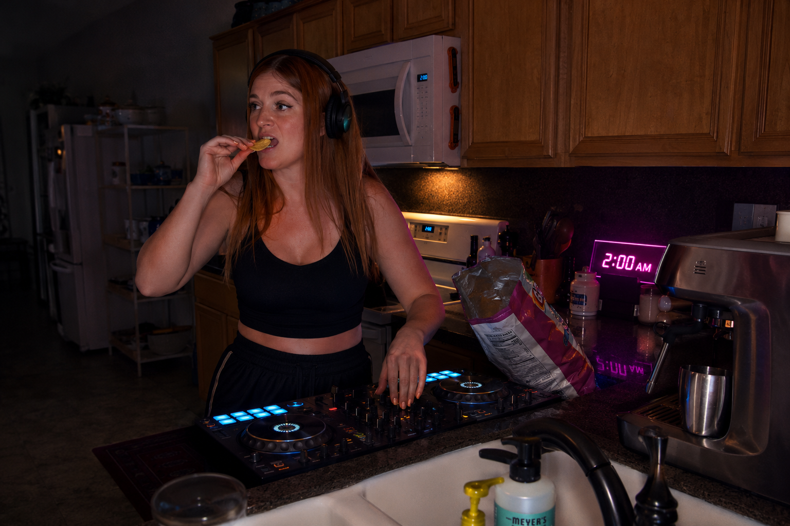 Female DJ eating potato chips in a kitchen at 2 AM while mixing music on a DJ controller, illustrating late-night snacking habits, irregular schedules, and nutrition challenges for DJs, musicians, and nightlife professionals.